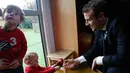 Presiden Prancis Emmanuel Macron bermain dengan anak-anak saat mengunjungi Graffiti's- Association Le Moulin Vert di Normandia, Prancis (5/4). Pada kunjungannya Presiden Emmanuel Macron berinteraksi dengan anak-anak autis. (AP / Christophe Ena, Pool)