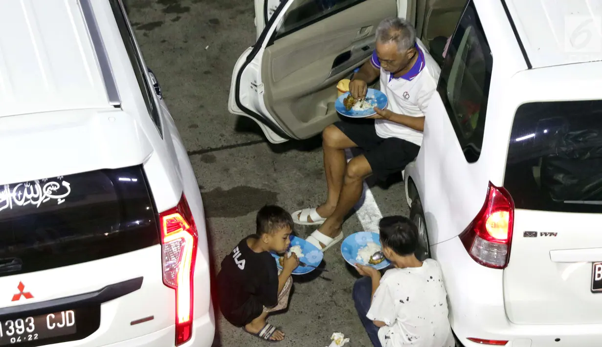 Pemudik makan bersama anak-anak sambil menanti waktu masuk kapal di Dermaga II Pelabuhan Penyebrangan Merak, Banten, Senin (3/6/2019). Sambil menanti waktu bongkar muat kapal penyebrangan, pemudik memanfaatkan waktu untuk makan bersama. (Liputan6.com/Helmi Fithriansyah)