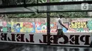 Warga melintasi mural bertema imbauan protokol kesehatan COVID-19 di kawasan Cakung Barat, Jakarta, Minggu (18/10/2020). Mural karya warga setempat tersebut bertujuan mengingatkan masyarakat akan pentingnya memakai masker, menjaga jarak, dan mencuci tangan. (merdeka.com/Iqbal S. Nugroho)