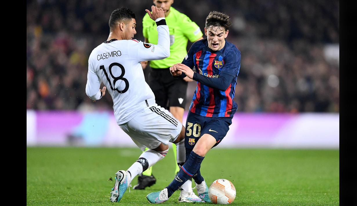 Pemain Barcelona, Gavi (kanan) berusaha melewati hadangan pemain Manchester United, Casemiro dalam pertandingan leg pertama play-off fase knockout Liga Europa 2022/2023 yang digelar di Stadion Spotify Camp Nou, Jumat (17/2/2023) dini hari WIB. (AP Photo/Joan Monfort)