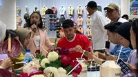Pemain Timnas Indonesia Shayne Pattynama saat menuliskan harapan di sebuah sandal untuk Indonesia bisa memenangkan pertandingan menghadapi China dengan skor 2-0. (Alit Binawan/Bola.com)