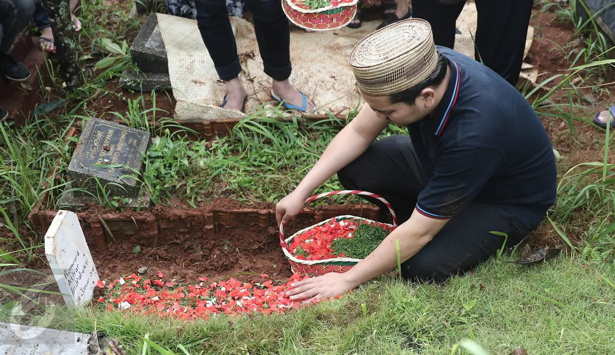 Presenter Indra Bekti menabur bunga di atas makam anak ketiganya, Kenward Athar Indrabekti, di TPU Kamboja, Radio Dalam,  Jakarta, Rabu (1/2). Anak ketiga Indra Bekti itu meninggal beberapa menit setelah dilahirkan. (Liputan6.com/Herman Zakharia)