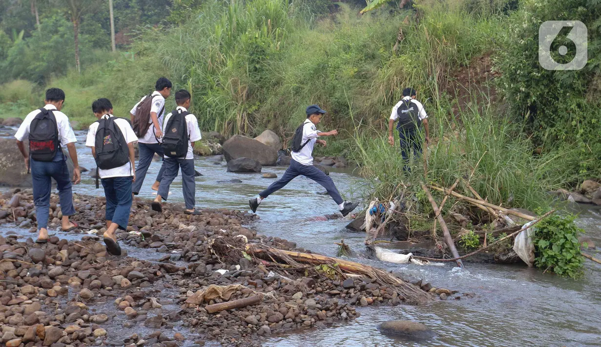 Tidak adanya jembatan penghubung di kampung tersebut, memaksa para pelajar dari berbagai tingkat sekolah menyeberangi Sungai Cihideung untuk menuju sekolah mereka masing-masing. (Liputan6.com/Herman Zakharia)