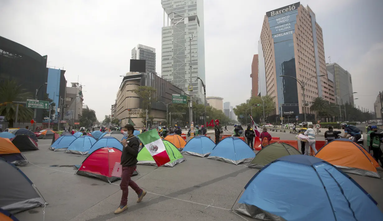 Demonstran yang menuntut pengunduran diri Presiden Meksiko Andres Manuel Lopez Obrador berkemah di perempatan Juarez Avenue dan Reforma Mexico City, Senin (21/9/2020). Para demonstran memutuskan untuk berkemah di jalan, memblokir Jalan Juarez sepenuhnya. (AP Photo/Fernando Llano)
