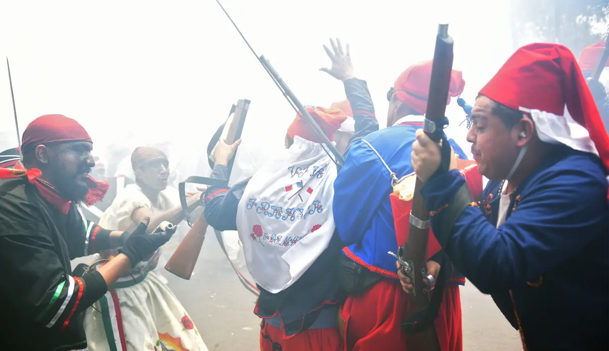Sejumlah peserta mengenakan kostum melakukan adegan perang saat memperingati Pertempuran Puebla di Penon de los Banos di Mexico City (5/5). Perang ini menceritakan kemenangan Meksiko atas Prancis pada tahun 1862. (AFP Photo/Pedro Pardo)