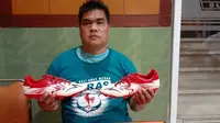 Borgo Pane mengenakan kaos komunitas jatah untuk Ricky Yacobi dan sepatu merek Specs yang dipakai terakhir almarhum pada laga trofeo di Lapangan ABC Senayan, Sabtu (21/11/2020) lalu. (Bola.com/Gatot Susetyo)