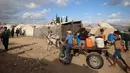 Warga dan anak-anak Palestina mengangkut jeriken berisi air bersih dari tangki air bergerak dengan gerobak keledai di kamp pengungsi Bureij di Jalur Gaza tengah pada 6 Oktober 2025. (Eyad BABA/AFP)