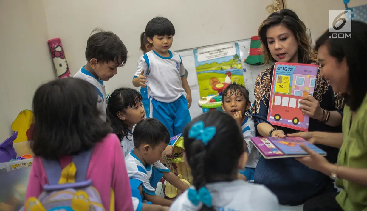 Pendiri Yayasan Pansophia Nusantara, Millie Lukito menunjukkan buku ke anak-anak PAUD CPI di Rusunawa Marunda, Jakarta (30/11). Selain memberi pendidikan kepada anak-anak, Millie mengajak orang tua mereka untuk berkreativitas. (Liputan6.com/Faizal Fanani)