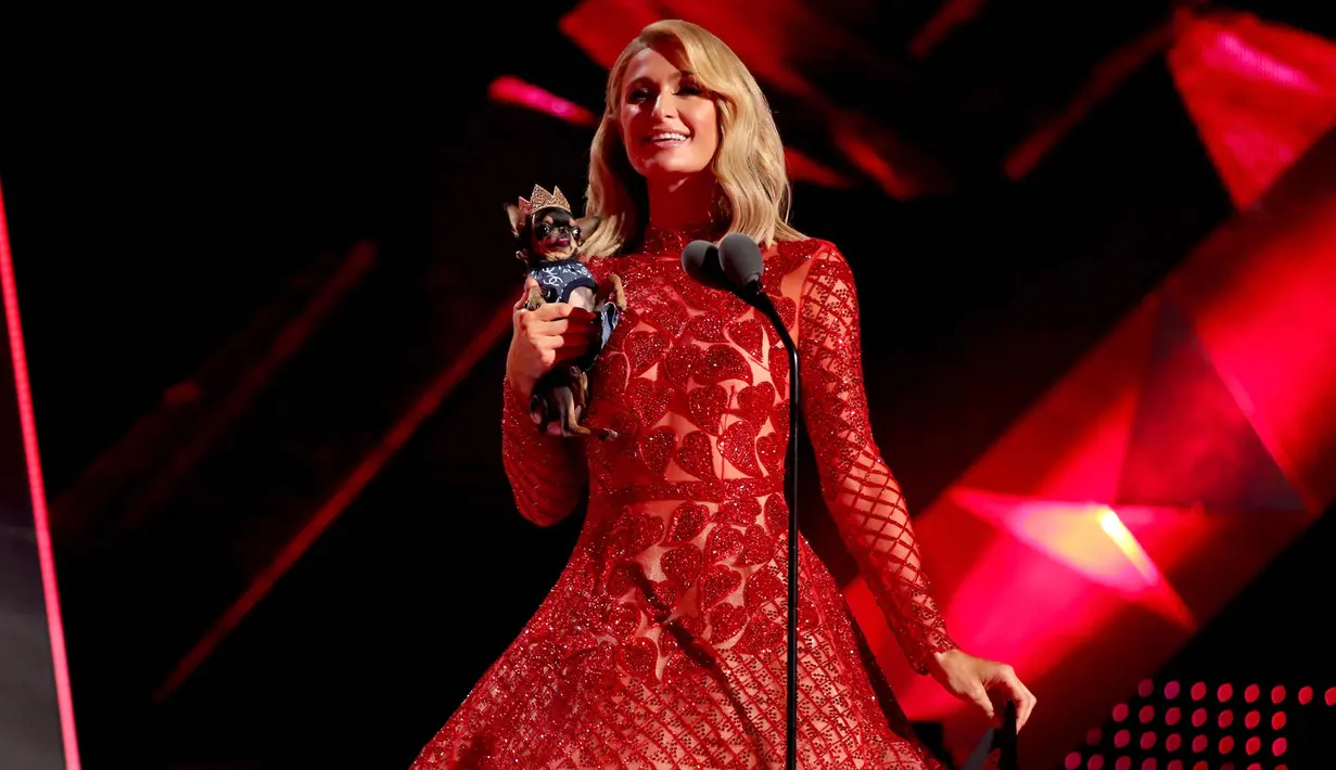 Aktris Paris Hilton berada di atas panggung selama iHeartRadio Music Awards 2018 di Inglewood, California, AS (11/3). Paris Hilton tampil dengan anjing Chihuahua peliharaannya. (AFP Photo/Christopher Polk)