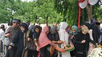 Anggota keluarga dan pelayat menaburkan bunga di pemakaman Mien Sugandhi di TMP Kalibata, Jakarta Selatan. (Liputan6.com/Winda Nelfira)