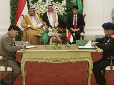 Kapolri Irjen Tito Karnavian (kiri) menandatangani kerjasama dengan pejabat Arab Saudi disaksikan oleh Presiden Jokowi dan Raja Arab Salman bin Abdulaziz Al-Saud di Istana Bogor, Jawa Barat, Rabu (1/3). (Liputan6.com/Angga Yuniar)