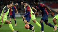 Gelandang Barcelona asal Spanyol #08, Pedri (tengah), dan penyerang Barcelona asal Spanyol #10, Ansu Fati (kanan), berlari membawa bola selama pertandingan Liga Spanyol antara FC Barcelona dan RCD Mallorca di Estadi Olimpic Lluis Companys di Barcelona, ​​Rabu dini hari WIB (23-4-2025). (LLUIS GENE/AFP)