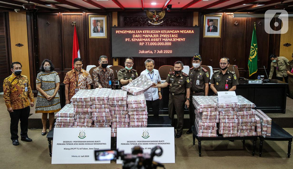 Jaksa Agung Muda Tindak Pidana Khusus Ali Mukartono (keempat kanan) menunjukkan tumpukan uang saat rilis eksekusi barang bukti Honggo Wendratno di Kejaksaan Agung RI, Jakarta, Selasa (7/7/2020). Kejagung menyita barang bukti uang Honggo Wendratno sebesar Rp 97 miliar. (Liputan6.com/Faizal Fanani)
