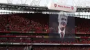 Foto pelatih Arsenal, Arsene Wenger, terpampang di tribun penonton saat perpisahan di Stadion Emirates (6/5/2018). Selama 22 tahun membesut Arsenal, Wenger telah mempersembahkan 17 gelar dan 704 Kemenangan. (AFP/Adrian Dennis)