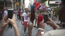 Seorang wanita berpose dengan wisatawan di ruas jalan Times Square, New York, AS, Selasa (18/8/2015).  Mereka memasang tarif untuk para wisatawan yang ingin berfoto. (REUTERS/Carlo Allegri)