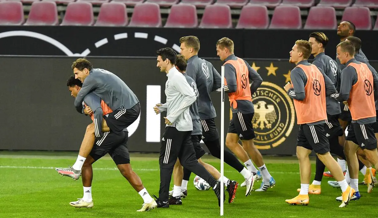 Pemain Jerman Serge Gnabry (kiri) berlari dengan menggendong Leon Goretzka saat sesi latihan jelang menghadapi Swiss pada pertandingan UEFA Nations League di Cologne, Jerman, Senin (12/10/2020). Jerman akan menghadapi Swiss pada Rabu (14/10/2020) dini hari WIB. (AP Photo/Martin Meissner)
