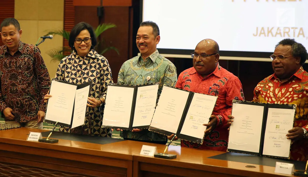 Menkue Sri Mulyani, Menteri ESDM, Ignasius Jonan, Gubernur Papua Lukas Enembe dan Bupati Mimika Eltinus Omaleng usai penandatangan perjanjian Pengambilan Saham Divestasi PT Freeport Indonesia, Jakarta, Jumat (12/2). (Liputan6.com/Johan Tallo)