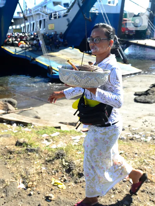 Umat Hindu Dharma membawa sesaji di depan dermaga kapal penyeberangan pada H-3 Lebaran Idul Fitri di Pelabuhan Gilimanuk, Bali, Rabu (19/4/2023). (merdeka.com/Arie Basuki)