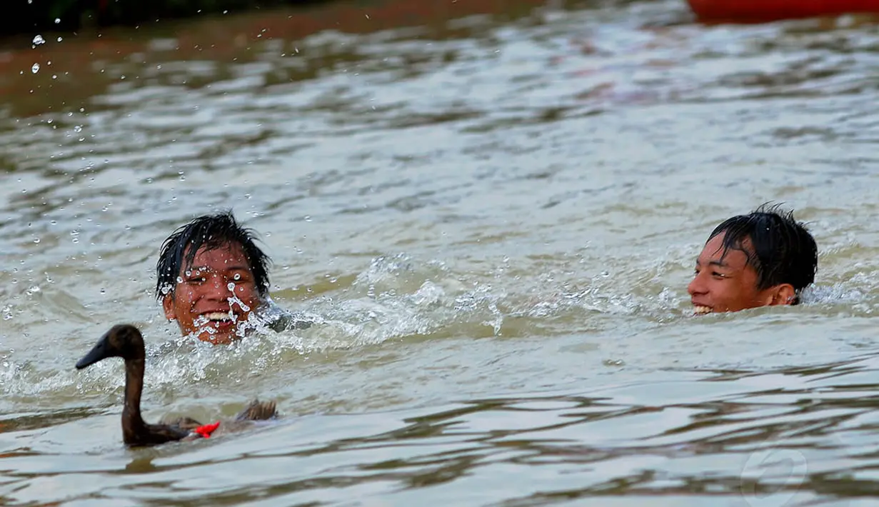 Terlihat dua bocah mengikuti lomba menangkap bebek di sungai Cisadane dalam rangka festival Peh Cun, Senin (2/6/14). (Liputan6.com/Faisal R Syam)