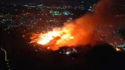 Kobaran api dan asap terlihat saat kebakaran Kastil Shuri di Okinawa, Jepang selatan, Kamis (31/10/2019). Sekitar 20 unit kendaraan pemadam kebakaran dan lebih dari 50 petugas pemadam kebakaran dikerahkan untuk memadamkan api. (Jun Hirata/Kyodo News via AP)