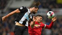 Striker Newcastle, Andy Caroll, duel udara dengan bek Manchester United, Marcos Rojo, pada laga Premier League di Stadion St James Park, Newcastle, Minggu (6/10). Newcastle menang 1-0 atas MU. (AFP/Paul Ellis)