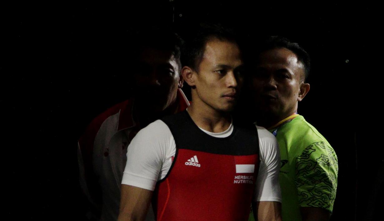Lifter Suratman bersiap melakukan angkatan saat SEA Games 2019 cabang angkat besi nomor 55 kg di Stadion Rizal Memorial, Manila, Minggu (1/12). Dirinya meraih perak dengan total angkatan 250 kg. (Bola.com/M Iqbal Ichsan)