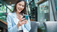 Seorang perempuan transaksi digital melalui smartphone. (Shutterstock/WHYFRAME)