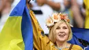 Hiasan di kepala dan bendera Ukraina menambah kecantikan suporter ini yang hadir ketika Ukraina melawan Jerman di Stade Pierre Mauroy, Lille. (12/6/2016). (AFP/Patrik Stollarz)