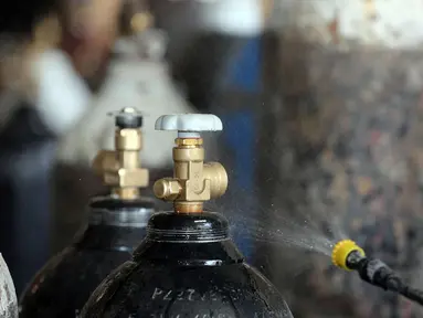 Seorang pekerja mendisinfeksi sejumlah tabung oksigen di Baghdad, Irak (7/7/2020). Pabrik pengisian oksigen milik pemerintah di Irak meningkatkan pengisian tabung oksigen dan gas cairnya untuk memenuhi permintaan rumah sakit di tengah terus bertambahnya infeksi COVID-19. (Xinhua)