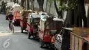 Warga melintas di sisi motor gerobak sampah di Tempat Pembuangan Sampah Sementara Kalibata, Jakarta, Rabu (4/11/2015). Penumpukan sampah terkait aksi pemblokadean jalan menuju TPST Bantar Gebang. (Liputan6.com/Helmi Fithriansyah)