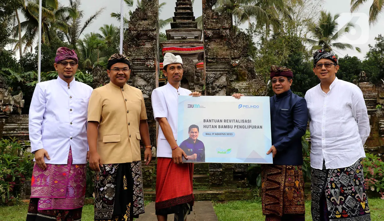 Wakil Direktur Utama PT Pelabuhan Indonesia (Pelindo) Persero, Hambra Samal (kedua kanan) bersama Deputi Bidang SDM, Teknologi, dan Informasi Kementerian BUMN, Tedi Bharata (kedua kiri) menyerahkan bantuan untuk revitalisasi hutan bambu desa Penglipuran, Kabupaten Bangli, Bali, Kamis (17/8/2023). (Liputan6.com/Helmi Fithriansyah)