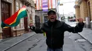 Seorang pria dengan bendera Bolivia merayakan pengunduran diri Presiden Evo Morales di La Paz, Minggu (10/11/2019). Morales yang telah memimpin Bolivia selama 14 tahun menyatakan mundur demi mengembalikan stabilitas keamanan usai diterpa gelombang unjuk rasa beberapa pekan terakhir. (AP/Juan Karita)