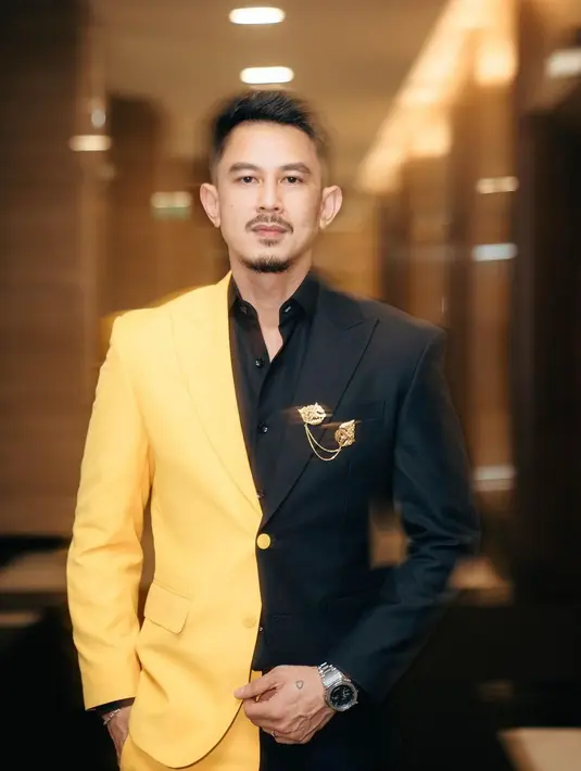 Fandy Christian mengenakan two tone set suit yang dipasangkan dengan kemeja hitam sebagai inner. Penampilan dipermanis dengan bros dari Tulola.  [@snap.nuel]