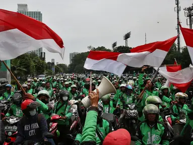 Massa driver Gojek berkumpul di jalan Asia Afrika, Jakarta, untuk selanjutnya menggelar unjuk rasa ke kantor pusat mereka di Kemang, Senin (3/10). Ratusan pengemudi Gojek itu menuntut penghapusan sistem performa atau rating. (Liputan6.com/Johan Tallo)