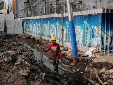 Pekerja membongkar saluran air (drainase) yang akan diperbaiki di jalan Hayam Wuruk, Jakarta Pusat, Selasa (20/11). Perbaikan dan pelebaran saluran air ini untuk mengantisipasi terjadinya banjir di kawasan tersebut saat hujan. (Liputan6.com/Johan Tallo)