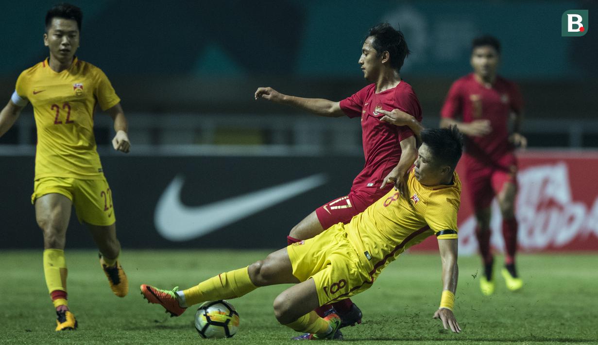 Striker Timnas Indonesia, Hanis Saghara, ditekel gelandang China, Jin Haoxiang, pada laga PSSI 88th U-19 di Stadion Pakansari, Jawa Barat, Selasa (25/9/2018). Indonesia kalah 0-3 dari China. (Bola.com/Vitalis Yogi Trisna)