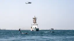 Dua kapal permukaan tak berawak (USV) T-12 Man-Portable Tactical Autonomous Systems (MANTAS) berlayar di perairan Teluk di depan kapal Penjaga Pantai Bahrain saat latihan angkatan laut bersama antara Komando Armada ke-5 AS dan pasukan Bahrain, 26 Oktober 2021. (MAZEN MAHDI/AFP)