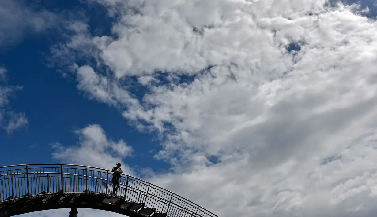 Orang-orang berjalan di sebuah instalasi tangga melingkar "Tiger and Turtle" di Duisburg, Jerman, 30 April 2018. Jika malam hari tiba, sisi kanan dan kirinya akan mengeluarkan cahaya, sehingga menambah keindahan tempat ini. (AP/Martin Meissner)