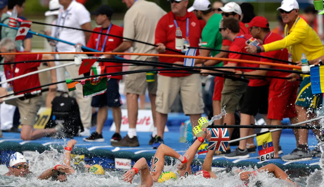 Para pelatih menyodorkan botol minuman kepada perenang yang sedang berlaga dalam lomba renang air terbuka nomor 10 km putra di Kejuaraan Renang Dunia di Yeosu, Korea Selatan, Selasa (16/7/2019). (AP Photo/Mark Schiefelbein)