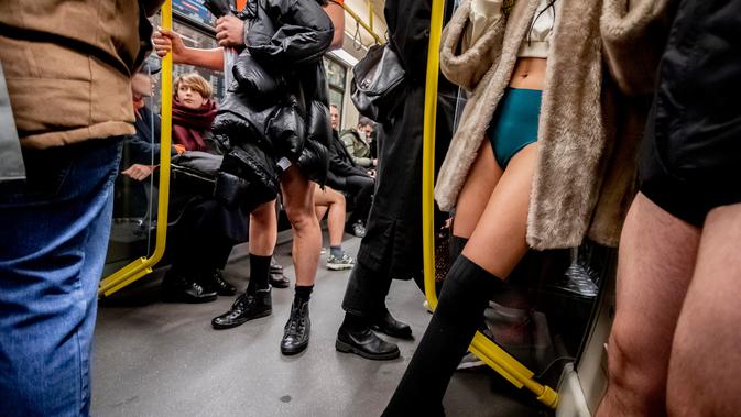 Penumpang berada di dalam kereta F selama No Pants Subway Ride di sebuah kereta bawah tanah di Berlin, Jerman (13/1). Acara ini dimulai pada tahun 2002 dengan peserta hanya tujuh orang. (AFP Photo/Christoph Soeder)