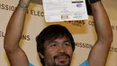 Manny Pacquiao mengangkat Sertifikat Pencalonan Senator  dirinya di Mei 2016 pemilihan nasional, di Komisi Pemilihan Umum, Manila, Filipina (16/10/2015). Pacquiao ditemani istrinya Jinkee dan anaknya Michael. (REUTERS/Erik De Castro)
