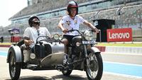 Pembalap Repsol Honda, Marc Marquez (kanan) dan mantan atlet kriket India, Suresh Raina mengendarai motor roda tiga di Sirkuit Buddh, New Delhi, India menjelang MotoGP India 2023 pada 21 September 2023. (AFP/Money Sharma)