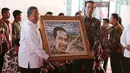 Presiden Jokowi bersama Menteri Koordinator bidang Perekonomian Darmin Nasution memegang karya foto yang bergambar wajahnya saat pameran hasil lomba foto pembangunan infrastruktur di Silang Monas, Jakarta, Minggu (27/8). (Liputan6.com/Angga Yuniar)