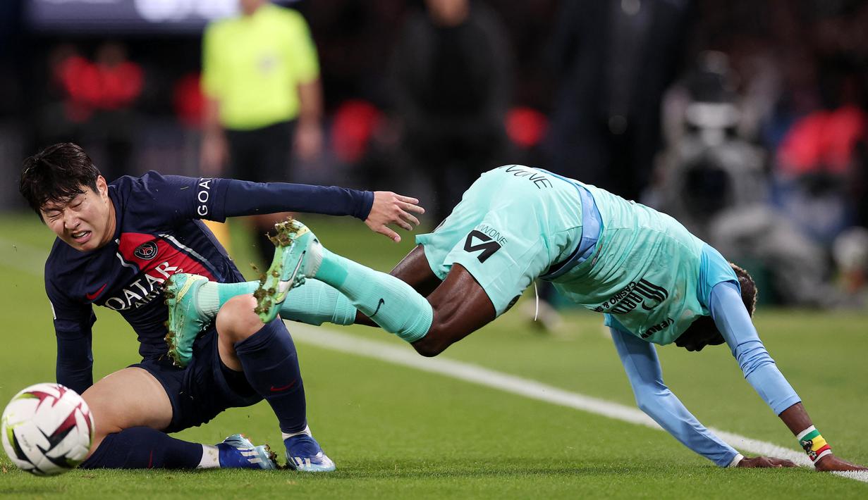 Pemain Paris Saint-Germain, Lee Kang-in, berusaha merebut bola dari pemain Montpellier, Falaye Sacko, pada laga Liga Prancis di Stadion Parc des Princes, Sabtu (4/11/2023). (AFP/Franck Fife)