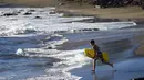 Seorang anak sedang membawa papan selancarnya untuk bermain di pantai Lahaina , Maui , Hawaii, Rabu (30/7/2015).  Hawaii merupakan salah satu daerah yang mempunyai tempat wisata terkenal di dunia. (REUTERS/Marco Garcia)