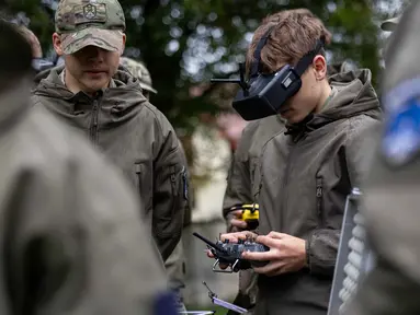 Seorang mahasiswa bernama Bartosz Ladocha mengenakan kacamata khusus untuk mengendalikan drone FPV (first-person-view) saat mengikuti kursus drone di Sekolah Militer, Legnica, Polandia Barat, pada 8 Oktober 2025. (Wojtek RADWANSKI/AFP)