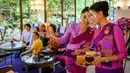 Pramugari mengenakan pelindung wajah saat melayani pelanggan di restoran pop-up bertema kabin pesawat di kantor pusat Thai Airways di Bangkok, 10 September 2020. Restoran pop-up ini awalnya hanya untuk sementara, tetapi antusias pengunjung membuat pihak maskapai berpikir ulang. (Mladen ANTONOV/AFP)