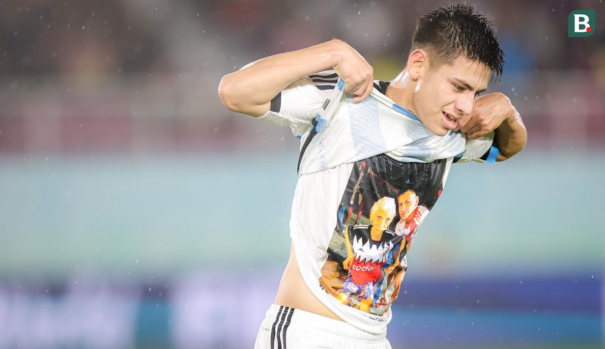 <p>Selebrasi pemain Timnas Argentina U-17, Claudio Echeverri dengan menunjukkan kaos bergambar sang nenek setelah mencetak gol ke gawang Timnas Mali U-17 yang akhirnya dianulir wasit akibat telah terperangkap offside pada laga perebutan tempat ketiga Piala Dunia U-17 2023 di Stadion Manahan, Solo, Jumat (1/12/2023). (Bola.com/Bagaskara Lazuardi)</p>