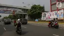 Pengendara kendaraan bermotor melintas dekat Alat Peraga Kampanye (APK) yang terpasang di kawasan Salemba, Jakarta, Kamis (7/12/2023).  (Liputan6.com/Herman Zakharia)