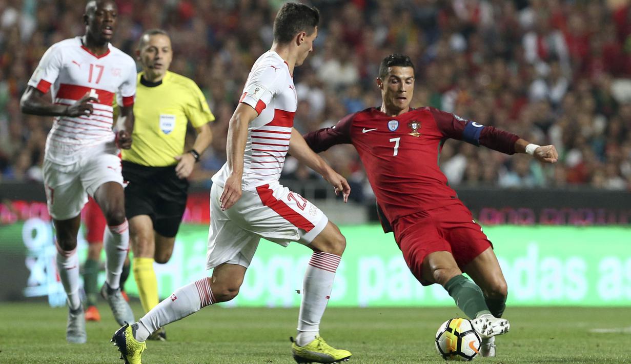 Striker Portugal, Cristiano Ronaldo, berusaha melewati pemain Swiss pada laga kualifikasi Piala Dunia 2018 di Stadion Luz, Selasa (10/10/2017). Portugal menang 2-0 atas Swiss.(AP/Armando Franca)